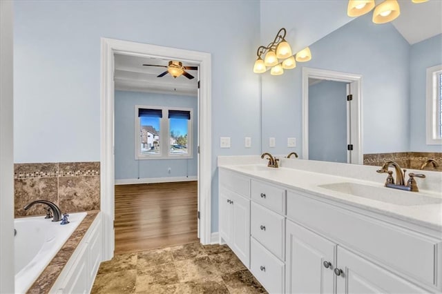 bathroom with vanity, ceiling fan, a bathtub, and a healthy amount of sunlight