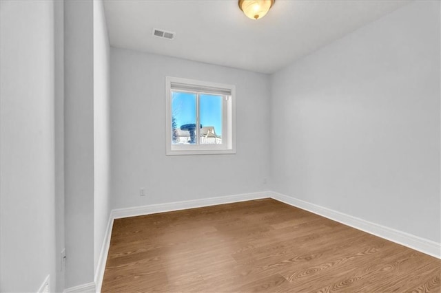 spare room featuring wood-type flooring