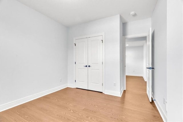 unfurnished bedroom featuring light hardwood / wood-style flooring and a closet