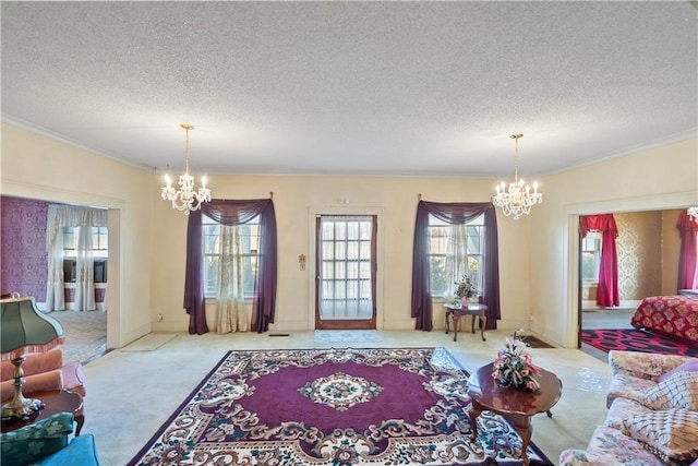 carpeted living room featuring ornamental molding, a textured ceiling, and an inviting chandelier