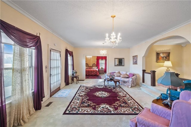 living room with carpet floors, a notable chandelier, a textured ceiling, and ornamental molding