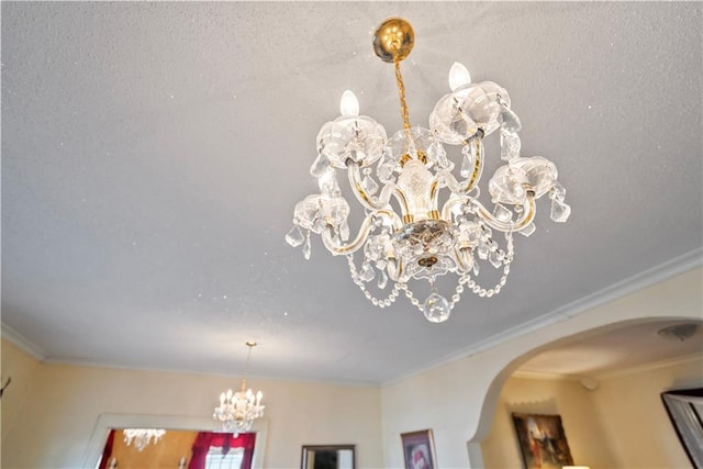 interior details featuring an inviting chandelier, arched walkways, and crown molding