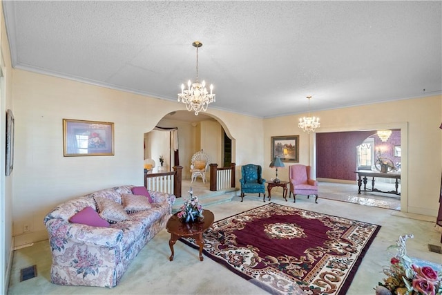 carpeted living room with an inviting chandelier, ornamental molding, and a textured ceiling