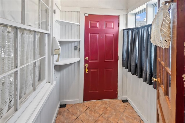 foyer with light tile patterned flooring and baseboards