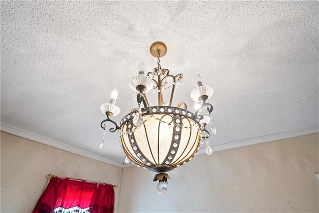 details featuring a textured ceiling, ornamental molding, and a notable chandelier