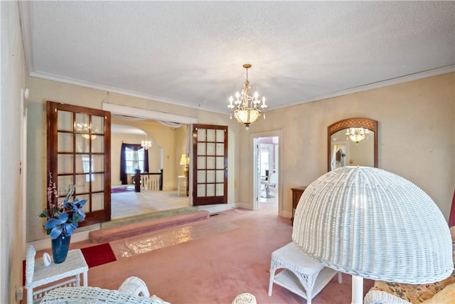 interior space featuring an inviting chandelier, ornamental molding, light carpet, and a textured ceiling