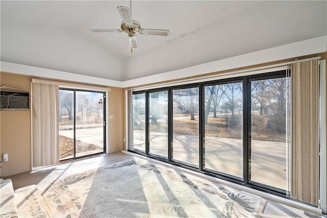 empty room with a ceiling fan, an AC wall unit, a healthy amount of sunlight, and vaulted ceiling