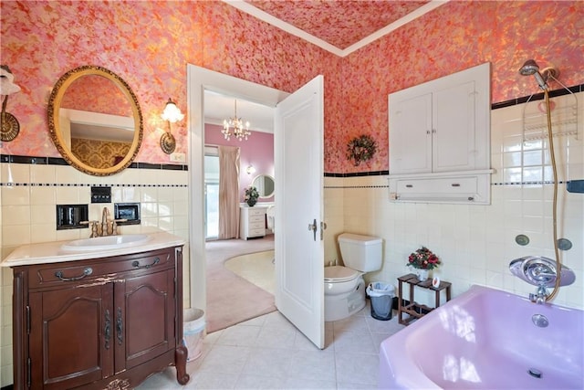 bathroom with a wainscoted wall, tile walls, toilet, a tub, and wallpapered walls