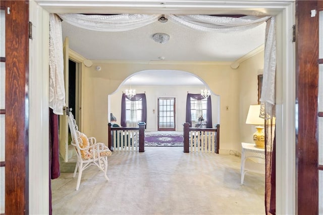 corridor featuring ornamental molding, light colored carpet, and a chandelier