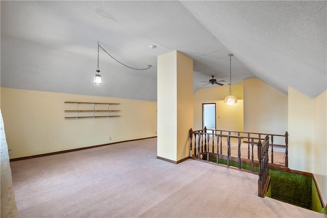 additional living space with carpet, baseboards, vaulted ceiling, and a textured ceiling