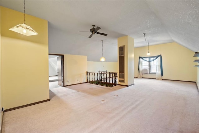 interior space featuring ceiling fan, lofted ceiling, carpet flooring, and a textured ceiling