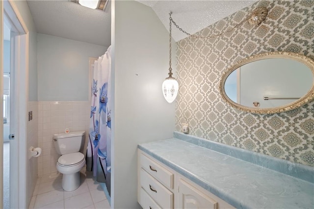 bathroom featuring toilet, tile walls, a textured ceiling, vanity, and tile patterned flooring