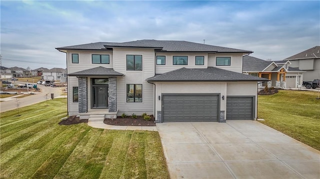 prairie-style house with an attached garage, roof with shingles, concrete driveway, and a front yard