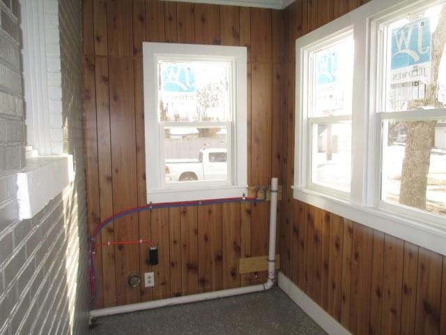 doorway with dark colored carpet and wood walls