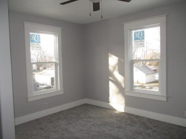 unfurnished room featuring dark carpet and ceiling fan