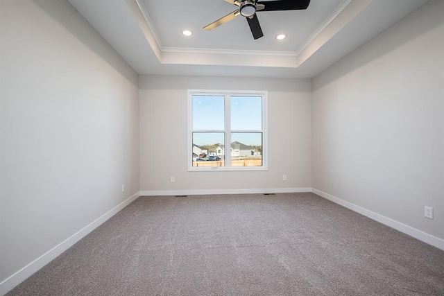 carpeted empty room with crown molding, ceiling fan, and a tray ceiling