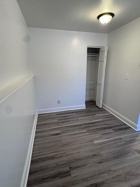 unfurnished bedroom with a closet and dark hardwood / wood-style floors