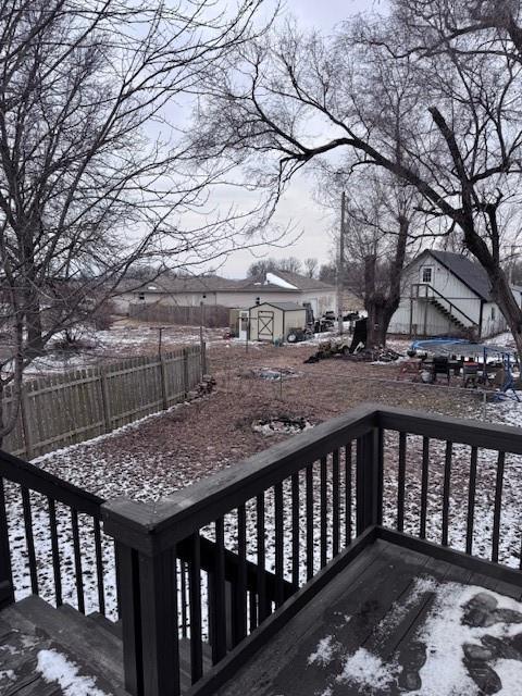 snow covered deck with a storage shed