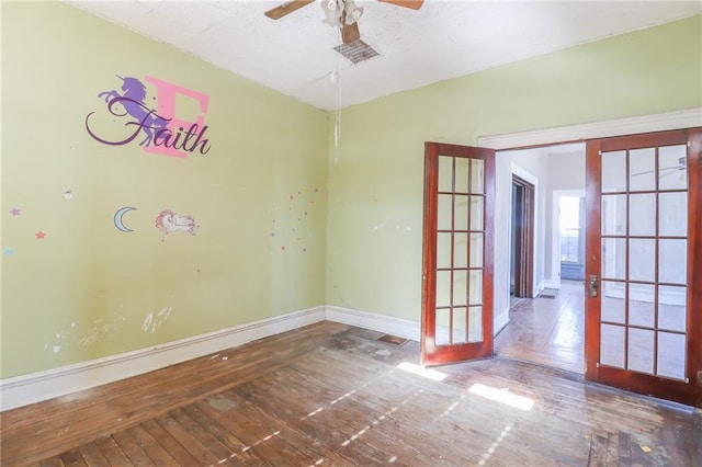 empty room featuring french doors, ceiling fan, and hardwood / wood-style floors