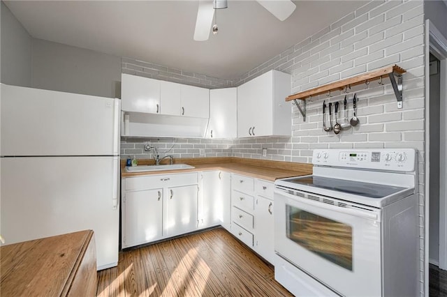 kitchen featuring tasteful backsplash, sink, white cabinets, hardwood / wood-style flooring, and white appliances