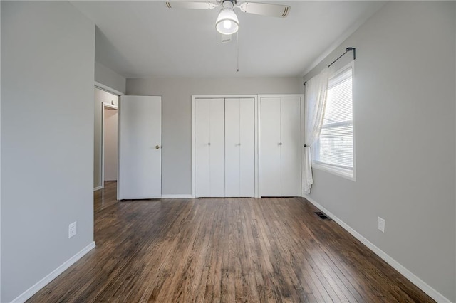 unfurnished bedroom with ceiling fan and dark hardwood / wood-style floors