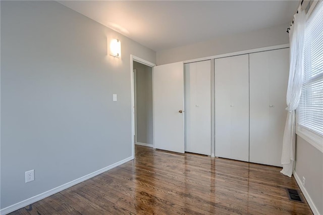 unfurnished bedroom featuring hardwood / wood-style flooring and a closet