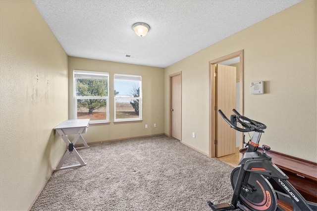 workout area with a textured ceiling, visible vents, carpet flooring, and a textured wall