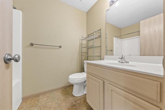 full bath featuring baseboards, vanity, and toilet