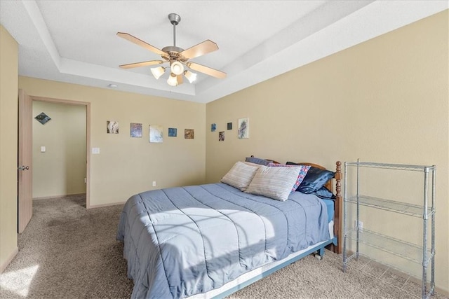 bedroom with ceiling fan, carpet, a raised ceiling, and baseboards