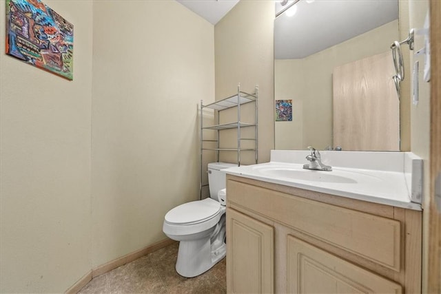 bathroom with tile patterned floors, vanity, toilet, and baseboards