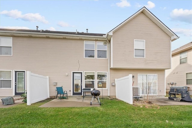 rear view of property with a yard, a patio area, and fence