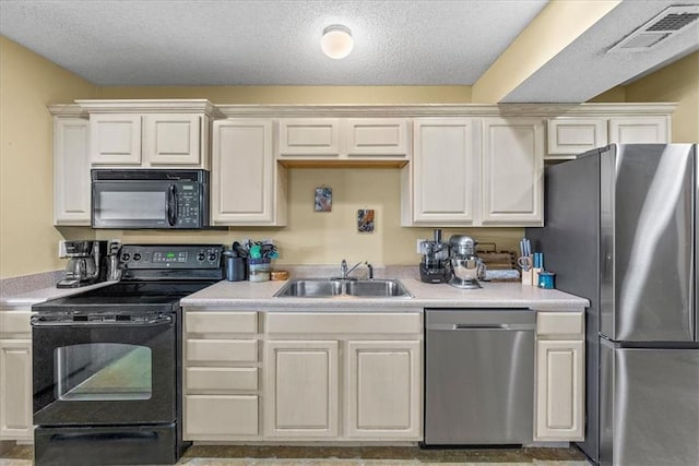 kitchen featuring black appliances, light countertops, a sink, and visible vents