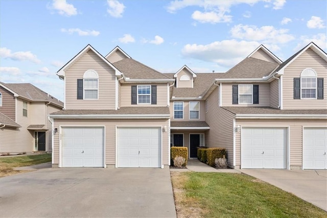 view of front of property featuring a garage, roof with shingles, and driveway