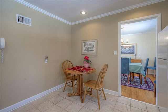 dining area featuring baseboards, light tile patterned flooring, visible vents, and crown molding