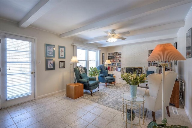 living area with ceiling fan, beamed ceiling, a fireplace, and baseboards