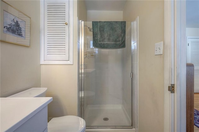 full bathroom with a stall shower, vanity, and toilet