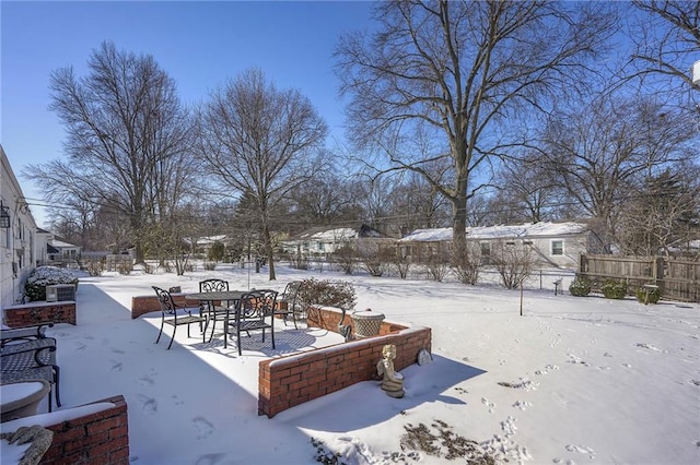 yard covered in snow featuring fence