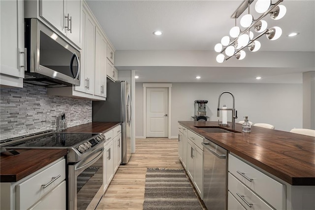 kitchen featuring wood counters, stainless steel appliances, and a sink