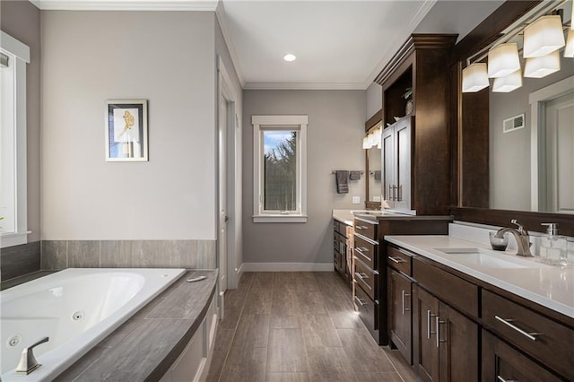 full bath with crown molding, two vanities, a sink, a whirlpool tub, and baseboards