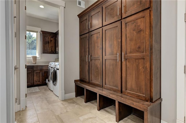 laundry room featuring crown molding, cabinet space, visible vents, washer and dryer, and baseboards