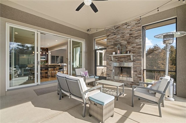 sunroom / solarium with an outdoor stone fireplace and a ceiling fan