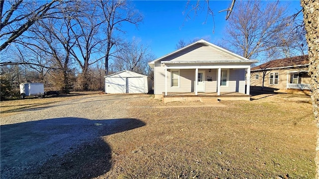 view of front of home featuring a porch, a garage, and an outbuilding