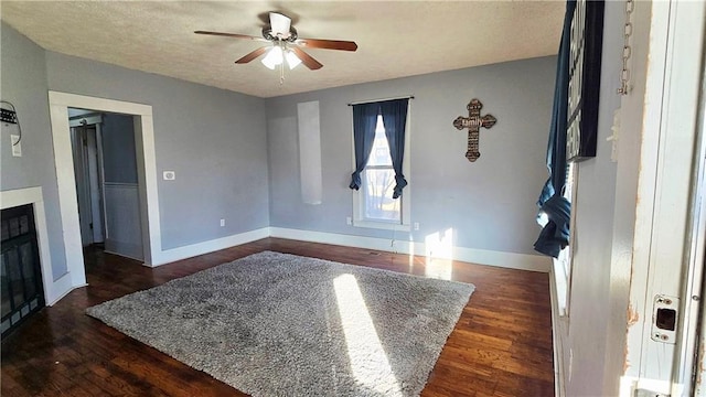 interior space featuring a textured ceiling, dark hardwood / wood-style floors, and ceiling fan