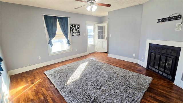 living room with dark wood-type flooring and ceiling fan