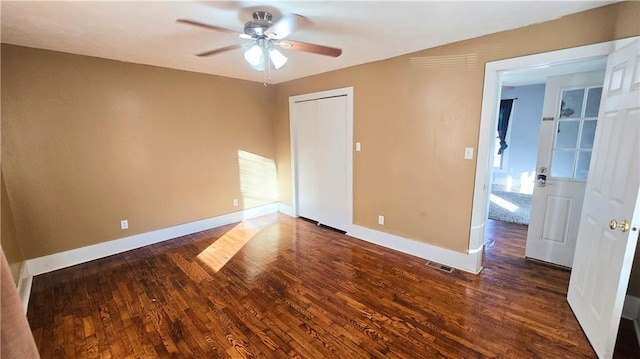 unfurnished bedroom featuring dark wood-type flooring and ceiling fan