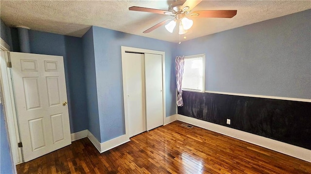 unfurnished bedroom with ceiling fan, hardwood / wood-style floors, a textured ceiling, and a closet