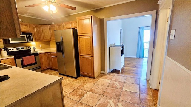 kitchen featuring appliances with stainless steel finishes, sink, and ceiling fan