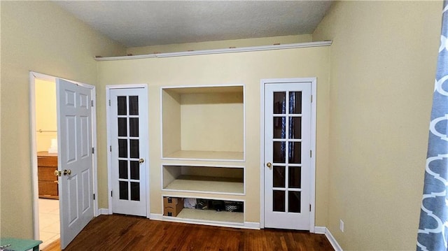 unfurnished living room with dark hardwood / wood-style flooring and built in features