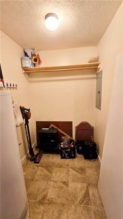 laundry area with electric panel and a textured ceiling