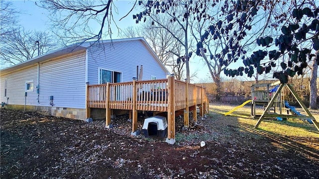 rear view of house featuring a playground and a deck